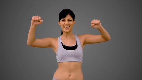 Fit-brunette-tensing-her-arms-and-smiling
