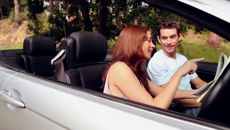 Pareja-Perdida-Mirando-Un-Mapa-De-Carreteras-En-Un-Coche-Descapotable-