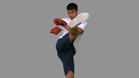 Boxer-performing-an-air-kick-on-grey-screen