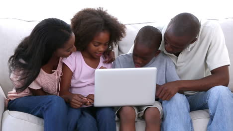 Family-looking-at-the-laptop-on-sofa