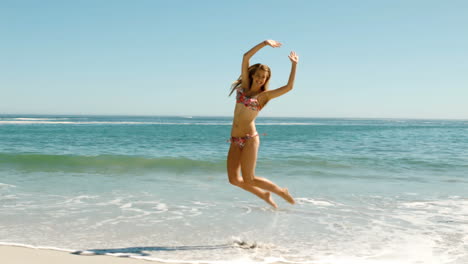 Attractive-young-woman-jumping-on-the-beach