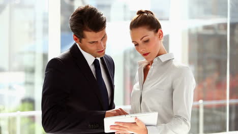 Business-people-standing-together-with-a-tablet