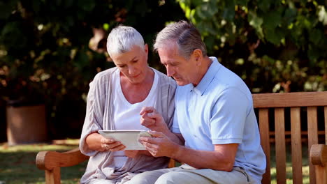 Älteres-Paar-Mit-Tablet-Computer-Auf-Einer-Bank