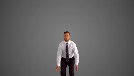 Businessman-jumping-and-doing-the-splits-on-grey-background