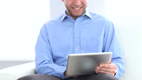 Businessman-using-a-tablet-on-a-couch