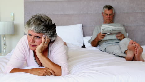 Woman-worried-about-something-while-her-husband-is-reading-newspapers