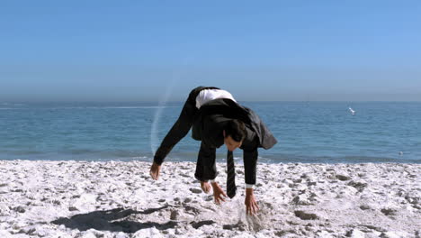 Businessman-doing-acrobatics-on-the-beach