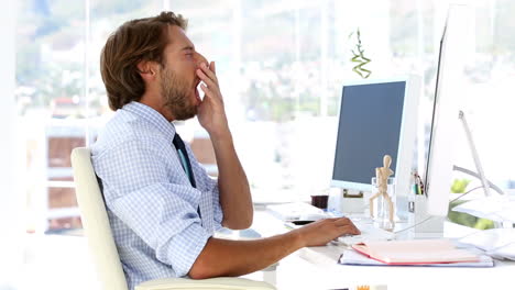 Businessman-yawning-at-his-desk