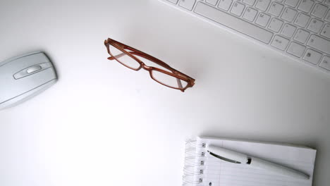 Red-glasses-falling-onto-an-office-desk