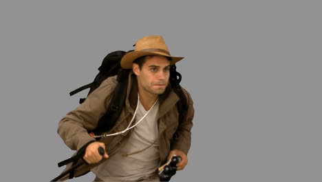 Man-orienteering-while-holding-a-hiking-stick-on-grey-screen