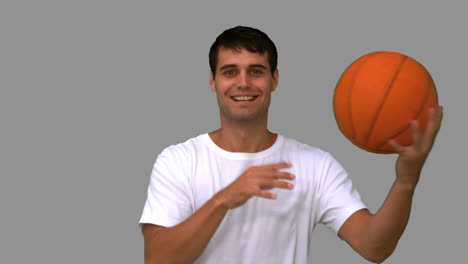 Man-playing-with-a-basketball-on-grey-screen