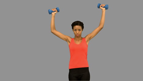 Woman-lifting-dumbbells-on-grey-screen