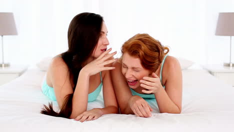 Dark-haired-woman-talking-to-her-friend-lying-on-bed