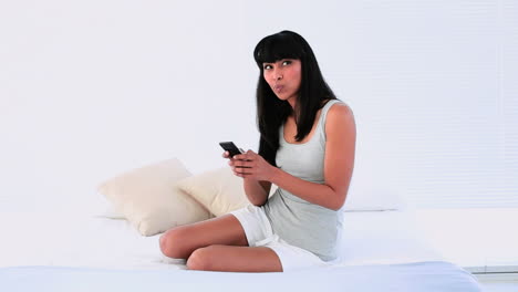 Attractive-woman-sending-a-text-message-on-her-bed