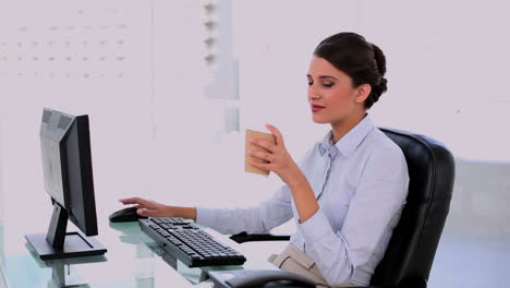 Content-beautiful-businesswoman-using-computer-and-enjoying-coffee