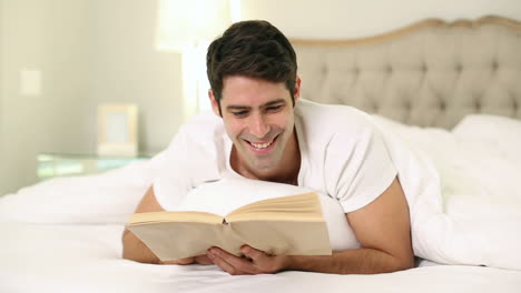 Lächelnder-Gutaussehender-Mann-Beim-Lesen-Im-Bett