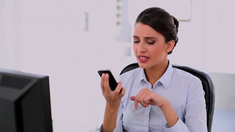Annoyed-beautiful-businesswoman-using-her-mobile-phone