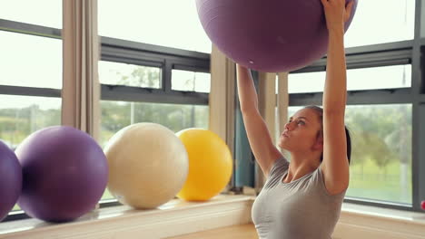 Mujer-Morena-Deportiva-Levantando-Pelota-De-Ejercicio