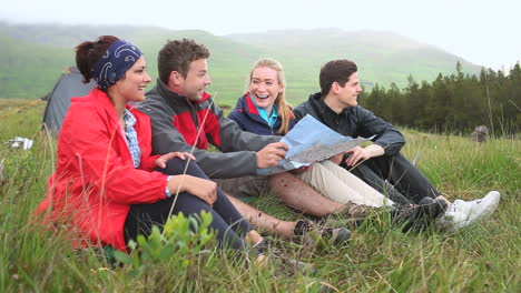 Friends-on-a-camping-trip-laughing-together-and-reading-map