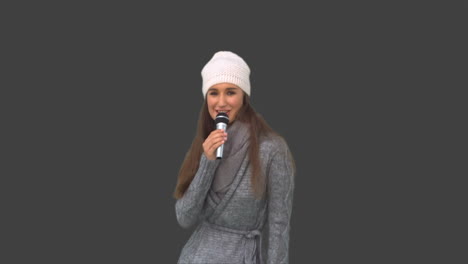 Fröhliches-Junges-Model-In-Winterkleidung-Singt-Am-Mikrofon