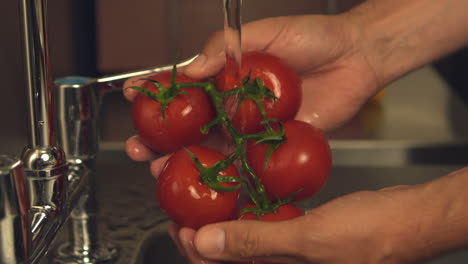 Manos-Lavando-Tomates-Bajo-El-Grifo-De-Agua.-