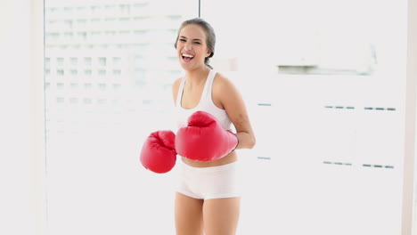 Beautiful-young-woman-punching-with-red-boxing-gloves