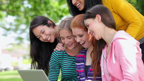 Schüler-Schauen-Gemeinsam-Draußen-Auf-Den-Laptop-Und-Lachen