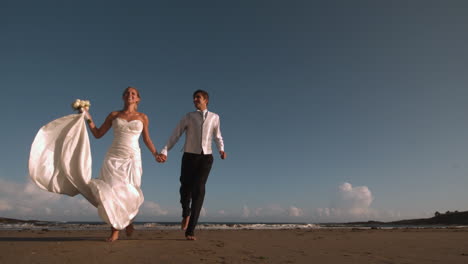 Cheerful-bridal-couple-running-on-the-beach