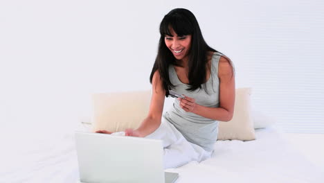 Attraktive-Frau-Beim-Online-Shopping-Mit-Laptop-Auf-Ihrem-Bett