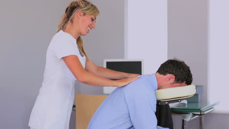 Masseuse-giving-businessman-a-shoulder-massage