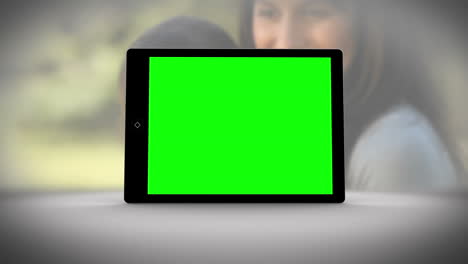Tableta-Con-Pantalla-Verde-Frente-A-La-Familia-Al-Aire-Libre