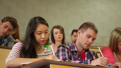 Students-listening-carefully-in-lecture-hall-and-taking-notes