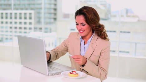 Smiling-attractive-businesswoman-buying-online-with-her-credit-card