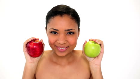 Beautiful-young-woman-holding-two-apples-smelling-them