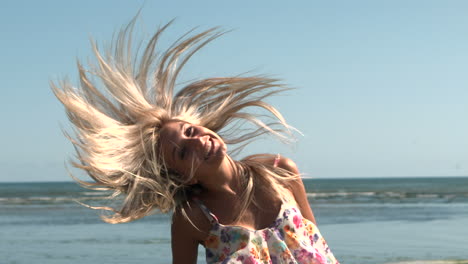 Rubia-Feliz-Sacudiendo-El-Cabello-En-La-Playa