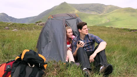 Couple-drinking-soup-in-their-tent-and-talking