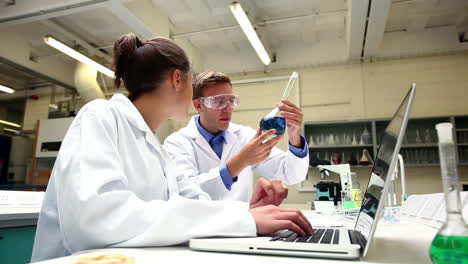 Konzentrierte-Naturwissenschaftsstudenten-Untersuchen-Chemikalien-Und-Benutzen-Einen-Laptop