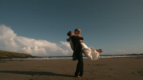 Happy-groom-spinning-his-bride-on-the-beach