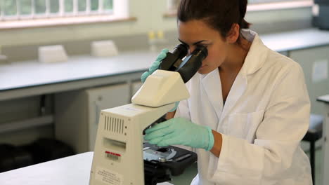 Estudiante-De-Ciencias-Mirando-A-Través-Del-Microscopio-En-El-Laboratorio