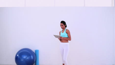 Fit-woman-using-her-digital-tablet-standing