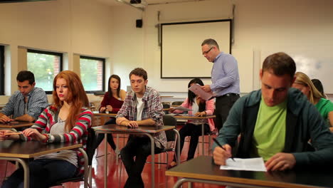 Profesor-Entregando-Trabajos-A-Sus-Alumnos