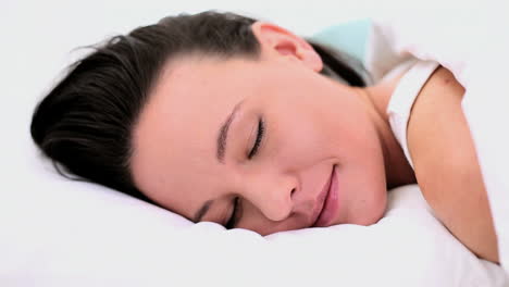 Calm-beautiful-woman-lying-in-her-bed-under-the-cover-while-sleeping-