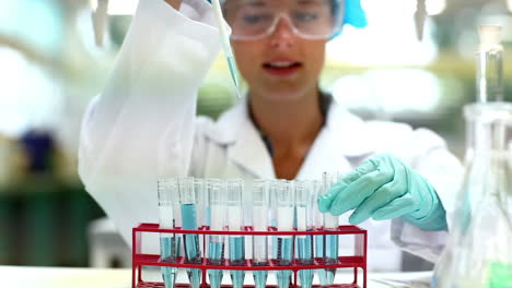 Pretty-science-student-using-pipette-to-fill-test-tubes