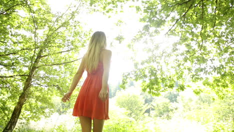 Beautiful-teen-spinning-in-the-sunlight-under-the-trees