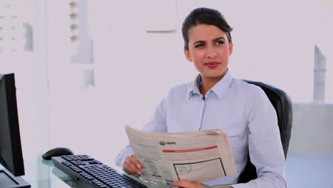 Nachdenkliche-Schöne-Geschäftsfrau-Mit-Computer-Beim-Zeitunglesen