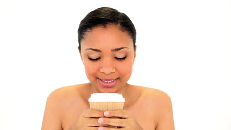Content-calm-woman-holding-a-disposable-cup-smelling-it