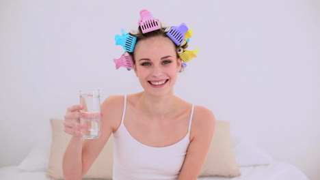 Young-model-in-hair-rollers-drinking-glass-of-water