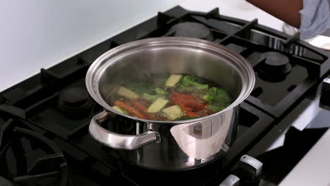 Handsome-man-smelling-boiling-vegetables