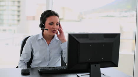 Call-center-agent-on-a-call-at-her-desk