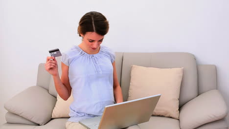 Schwangere-Frau-Benutzt-Ihren-Laptop-Zum-Online-Shopping-Auf-Dem-Sofa